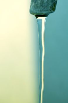 Tap of running water isolated on grey background