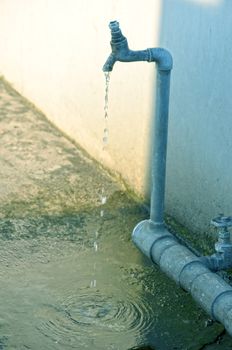 Tap of running water isolated on grey background