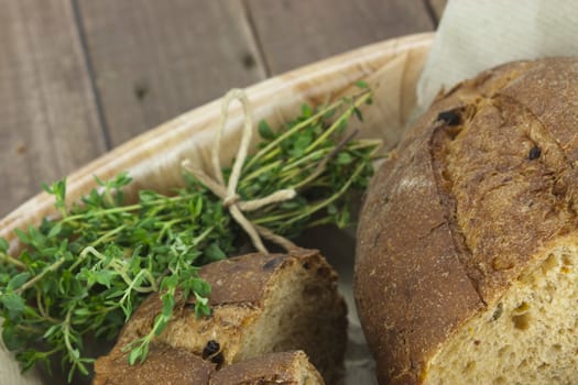 Loaf of wholemeal bread in a basket with brown paper