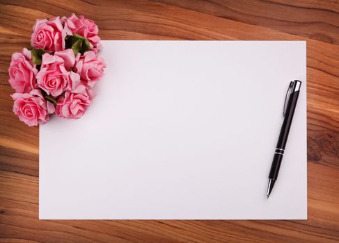 blank card with a pen and pink roses