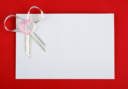 greeting card with hearts and bow on red background
