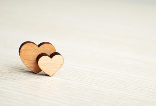 two hearts on a wooden surface with space for text