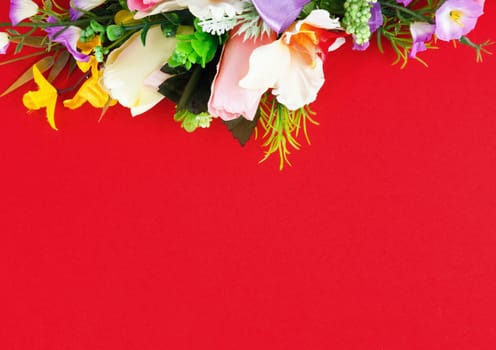 artificial flower arrangement on a red background with space for greetings