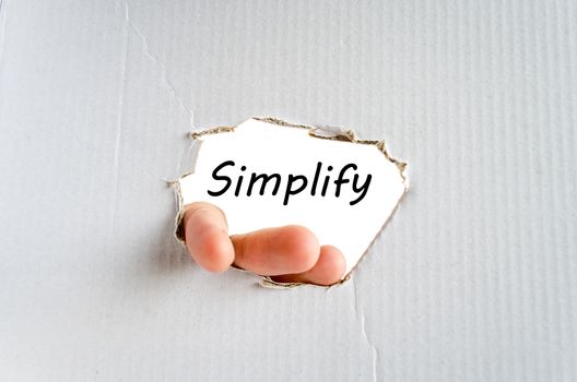 Hand and text Simplify on the cardboard background - business concept