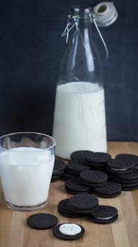 Chocolate sandwich cookies with vanilla creme filling and milk.