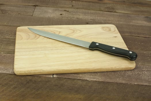 Wooden chopping board with an old knife