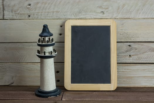 Lighthouse and blackboard set against a worn wooden background