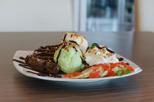 ice cream , chocolate waffles with chocolate sauce and whipping cream