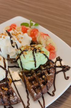 ice cream , chocolate waffles with chocolate sauce and whipping cream
