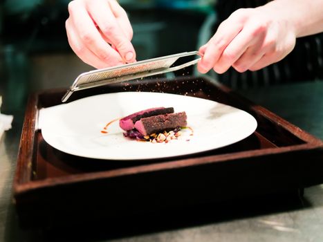 Chef Grating Spice on Deer Meat with Peanut