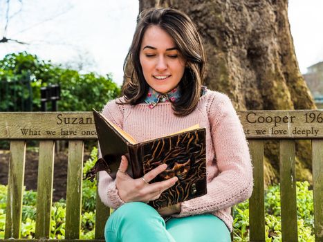 Woman Reading Book on Park Bench Close Up