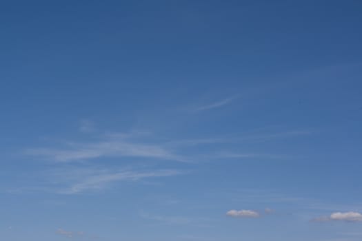 Smalll white clouds set against a blue sky