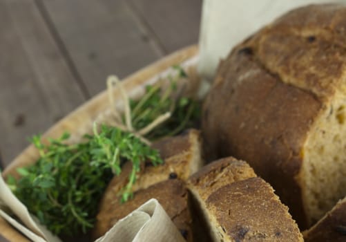 Loaf of wholemeal bread in a basket with brown paper