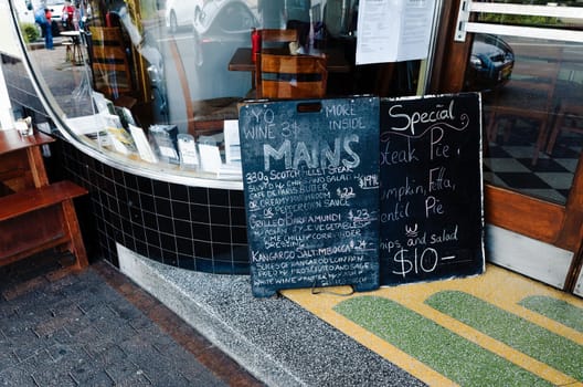 A chalkboard menu in front of a restaurant in Katoomba, Blue Mountains, Australia.