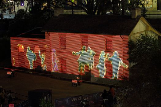 SYDNEY, AUSTRALIA - MAY 26, 2015;  Cadmans Cottage in lights for Vivid Sydney annual winter festival. Participants move to interact some of the imagey displayed.