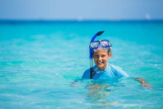 Portrait of happy cute girl wearing snorkeling mask ready to dive in the sea