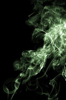 Smoke swirling with a green tint on a black background