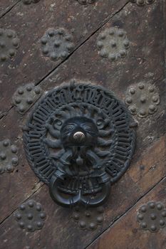 metallic bell on  wooden door of middle ages house