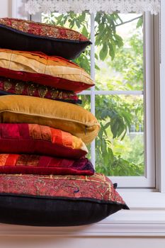 Close up Layered Authentic Squared Pillows In Front of Glass Window Inside the House.