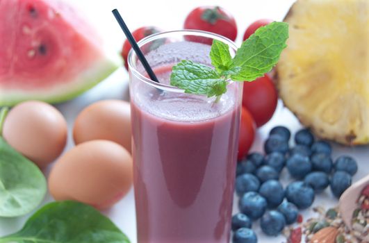 Anti cellulite foods, including blueberry smoothie, tomatoes, spinach, watermelon, seed mix and eggs, over a white background