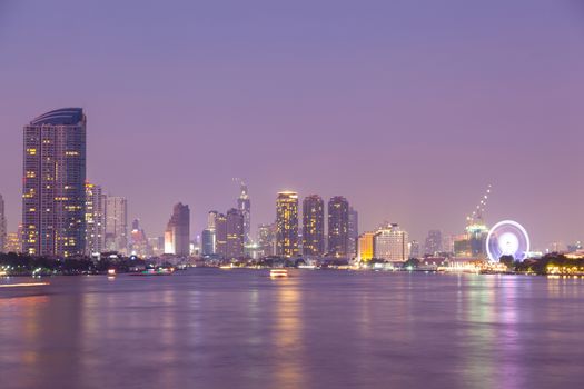 Bangkok city at night. Building a skyscraper lit A river through the city