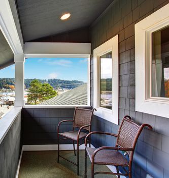 Covered small porch of dark blue Northwest home in Gig Harbor.