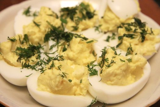 Boiled eggs sliced in halves stuffed and filling by pasta with dill