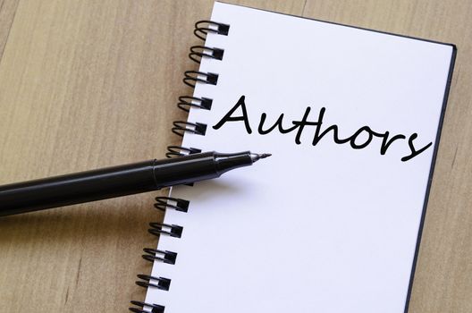 White notepad and ink pen on the wooden desk Authors concept