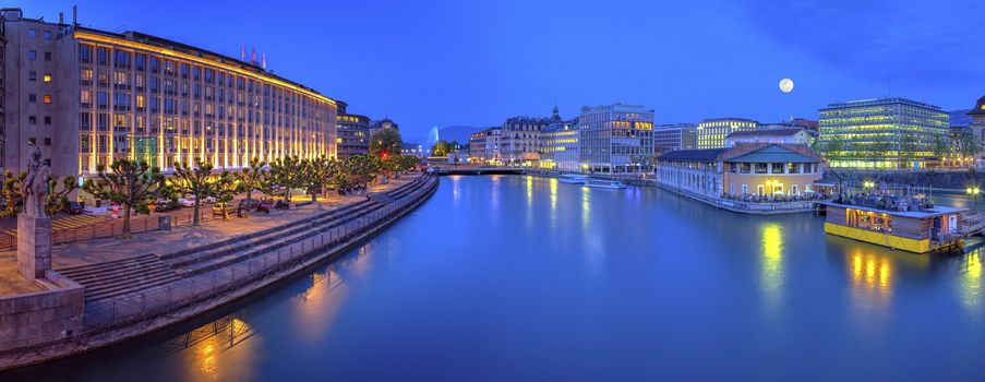 Urban view with famous fountain and Rhone river by night with full moon, Geneva, Switzerland, HDR