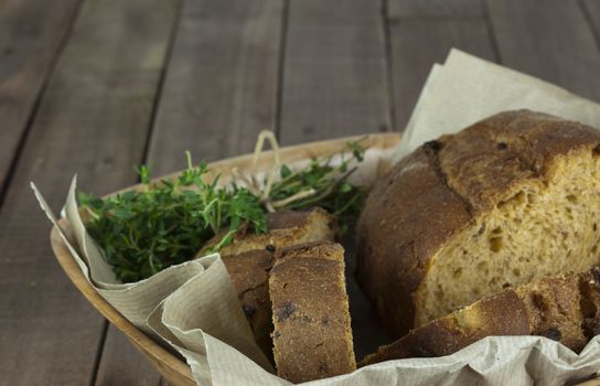 Loaf of wholemeal bread in a basket with brown paper