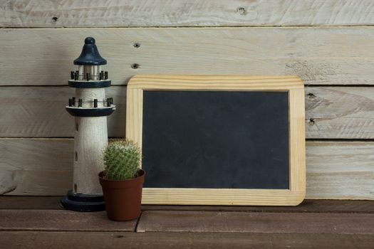 Lighthouse and blackboard set against a worn wooden background