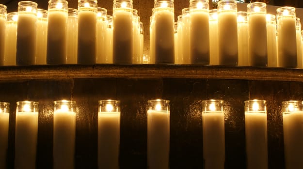 Photograph of a lot wax candles inside a temple
