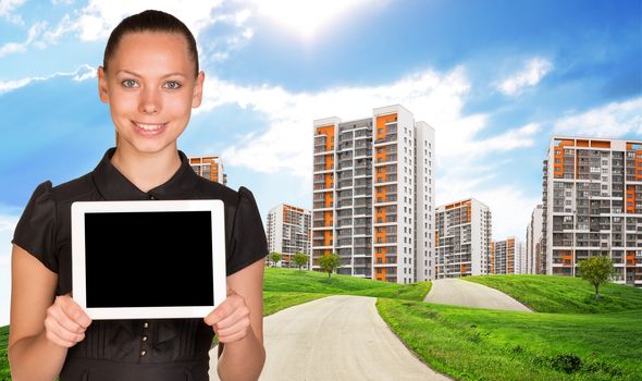 Businesslady holding tablet and colorful cityscape under blue sky with road 