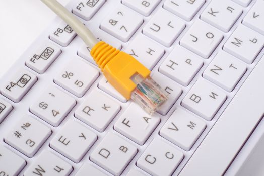 Computer keyboard with yellow cable, close up view