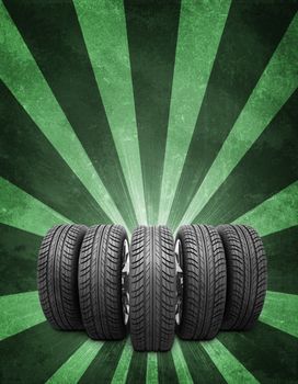 Wedge of new car wheels. Abstract green background is concrete surface and stripes at bottom