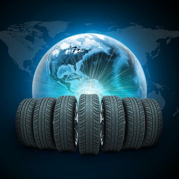 Wedge of new car wheels. Earth with light and world map on dark blue background. Elements of this image furnished by NASA
