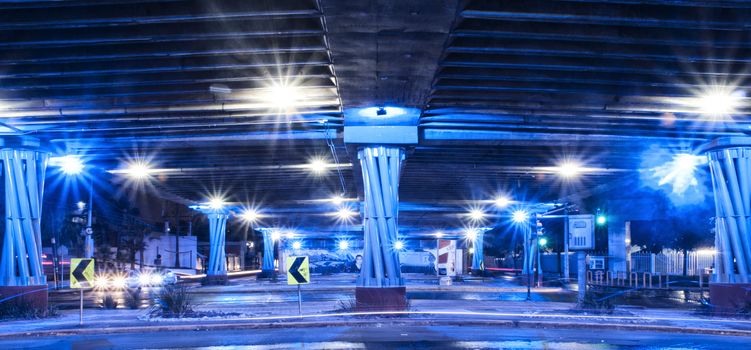 Photograph of an urban bridge in a night scene, under blue light