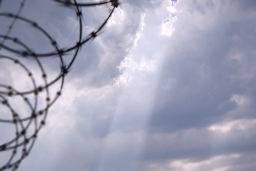 Photograph of a bright blue cloudy sky and a barb wire´s shadow or silhouette