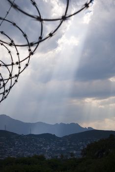 Photograph of a barb wire on a cloudy sky