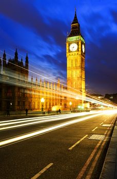 Big Ben, one of the most prominent symbols of both London and England, as shown at night along with the lights of the cars passing 
