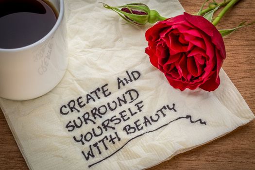 create and surround yourself with beauty - inspirational handwriting on a napkin with a cup of coffee and red rose