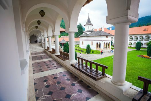 Sambata, Romania - June 24, 2012: Church inside Sambata de Sus Monastery seen trough a colonade in Transylvania, Romania
