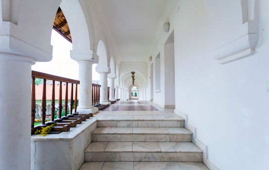 Arched colonade hallway at Sambata de Sus monastery in Transylvania, Romania