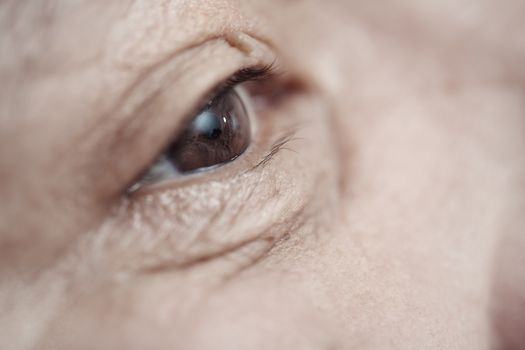 Close-up view on the eye of elderly human