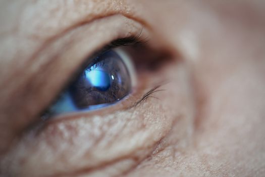 Close-up view on the eye of senior man. Horizontal photo