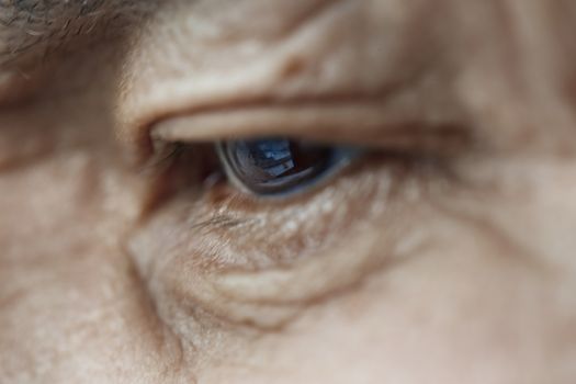 Close-up view on the eye of elderly human