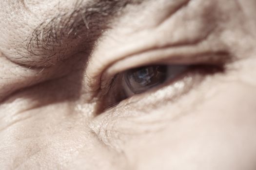 Close-up view on the eye of elderly human