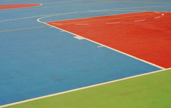 Basketball field has lines and boundaries are clearly marked and orderly.                               