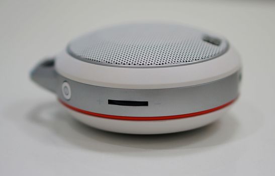 Round-shape portable loudspeaker, has button to decrease or increase the volume.                            