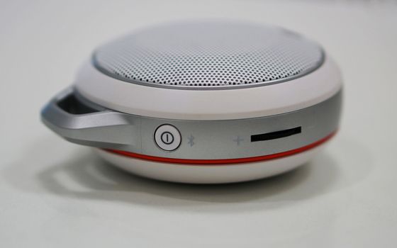 Round-shape portable loudspeaker, has button to decrease or increase the volume.                                